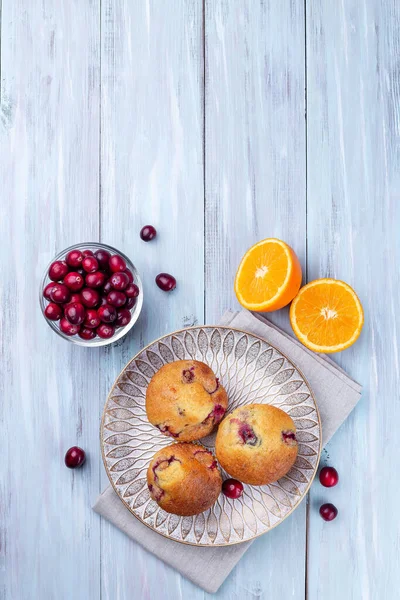 Homemade cranberry orange muffins on wooden plate, vertical, top view, copy space — Stockfoto