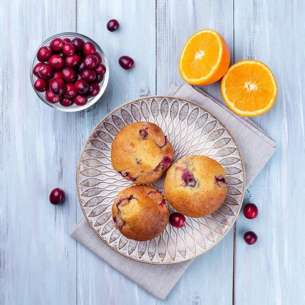Homemade cranberry orange muffins on wooden plate, top view, square format — Stockfoto
