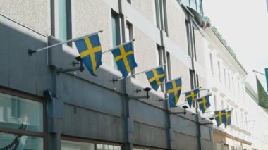 Göteborg şehir merkezindeki alışveriş caddesi binalarında İsveç bayrakları