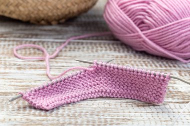 Şırıngalarla örgü örmek ve ahşap arka planda pembe iplik kesesi, yatay, yakın plan