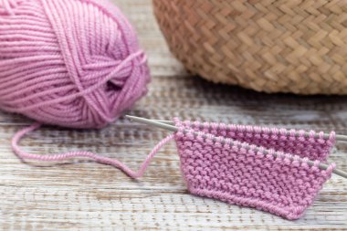 Şırıngalı örgü parçası ve ahşap arka planda pembe iplik kesesi, yatay, yakın plan