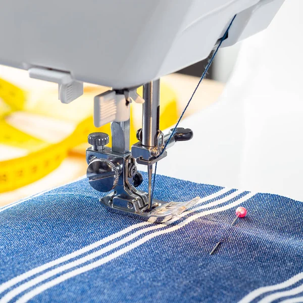 Máquina de costura com tecido branco azul listrado e linha, artesanato em casa ou hobby, formato quadrado — Fotografia de Stock