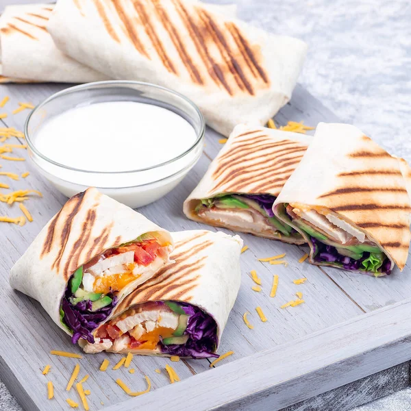 Chicken wraps with red cabbage, avocado, tomato, lettuce, cheddar cheese, on wooden tray, square — Stock Photo, Image