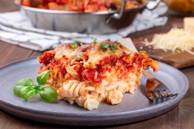 Köfteli makarna, mozarella, domates sosu ve fesleğen, gri tabakta, yatay.