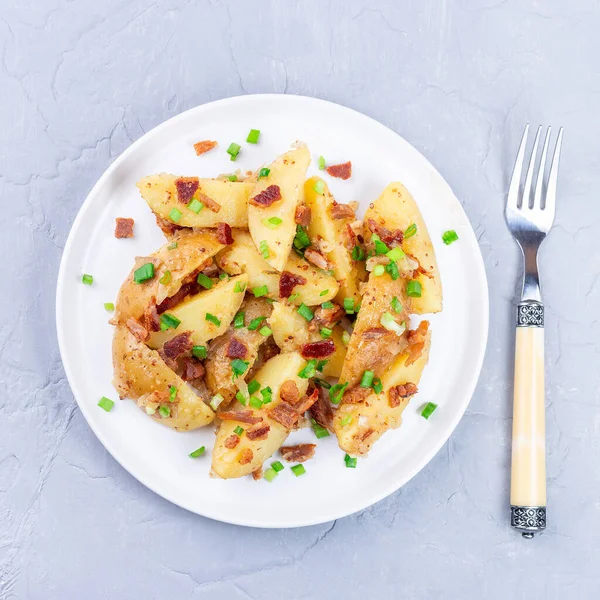 Картофельный салат с беконом и луком, облеченный яблочным уксусом и горчицей, на тарелке, на площади — стоковое фото