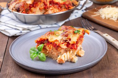 Köfteli makarna, mozarella, domates sosu ve fesleğen, gri tabakta, yatay.