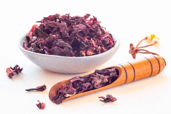 Karkade o foglie di tè rosso ibisco in cucchiaino da tè orientale e su un piatto, orizzontale — Foto Stock