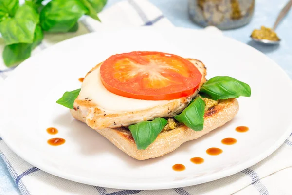 Сэндвич с открытым лицом с курицей, моцареллой, помидорами, песто и базиликом на поджаренном чиабатте, горизонтальный — стоковое фото