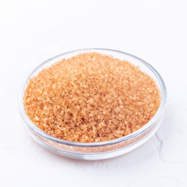 Kahverengi şeker kristalleri veya beyaz zemin üzerinde kamış şekeri, kare biçiminde