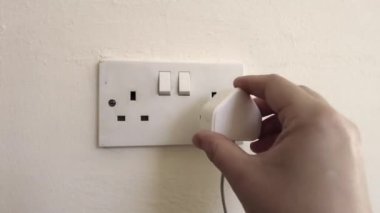 Plug in electrical appliance and switch on, UK British socket, 4k footage