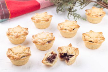 Geleneksel İngiliz Noel turtaları ya da meyveli turtalar, arka planda ışıkları olan yeşil ağaç dalı, yatay