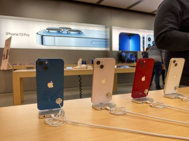Köln, Almanya - 1 Ekim 2021: Yeni iPhone 13 'ün yanı sıra iPhone 13 Pro ve iPhone 13 Mini' yi Apple Store 'da karşılaştıran ve test eden bir Alman fotoğrafçı.