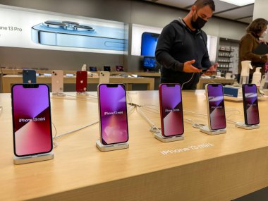 Köln, Almanya - 1 Ekim 2021: Yeni iPhone 13 'ün yanı sıra iPhone 13 Pro ve iPhone 13 Mini' yi Apple Store 'da karşılaştıran ve test eden bir Alman fotoğrafçı.