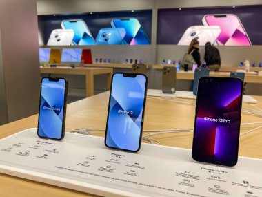 Köln, Almanya - 1 Ekim 2021: Yeni iPhone 13 'ün yanı sıra iPhone 13 Pro ve iPhone 13 Mini' yi Apple Store 'da karşılaştıran ve test eden bir Alman fotoğrafçı.