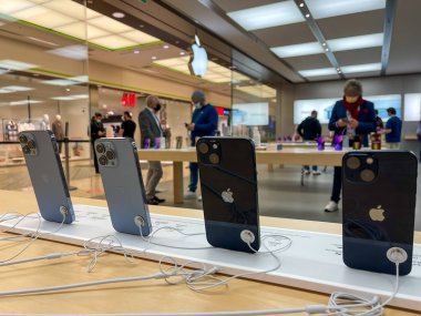 Köln, Almanya - 1 Ekim 2021: Yeni iPhone 13 'ün yanı sıra iPhone 13 Pro ve iPhone 13 Mini' yi Apple Store 'da karşılaştıran ve test eden bir Alman fotoğrafçı.