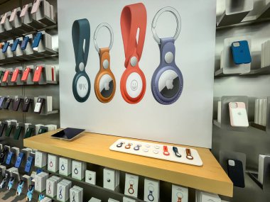 Köln, Almanya - 1 Ekim 2021: Bir Apple mağazasında farklı renklerde aksesuarlara sahip yeni Apple Havacılık etiketleri hakkında bilgi arayan bir Alman fotoğrafçı.