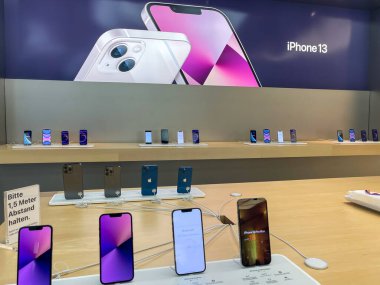 Köln, Almanya - 1 Ekim 2021: Yeni iPhone 13 'ün yanı sıra iPhone 13 Pro ve iPhone 13 Mini' yi Apple Store 'da karşılaştıran ve test eden bir Alman fotoğrafçı.