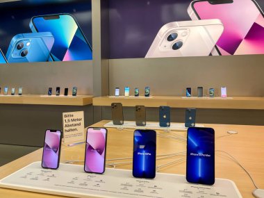 Köln, Almanya - 1 Ekim 2021: Yeni iPhone 13 'ün yanı sıra iPhone 13 Pro ve iPhone 13 Mini' yi Apple Store 'da karşılaştıran ve test eden bir Alman fotoğrafçı.
