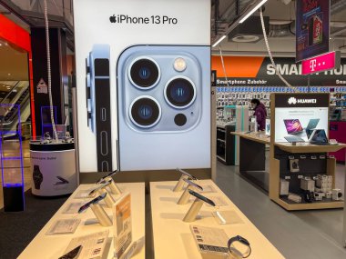 Köln, Almanya - 1 Ekim 2021: Yeni iPhone 13 'ün yanı sıra iPhone 13 Pro ve iPhone 13 Mini' yi Apple Store 'da karşılaştıran ve test eden bir Alman fotoğrafçı.