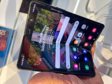 Köln, Almanya - 30 Eylül 2021: Bir Alman fotoğrafçı, yeni Samsung Galaxy Fold 5G modellerini Satürn 'deki elektronik pazarında izleyerek bir alışveriş malını ziyaret ediyor.