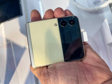 Köln, Almanya - 30 Eylül 2021: Bir Alman fotoğrafçı yeni Samsung Galaxy Z Flip 3 modelini Satürn 'ün elektronik pazarında izleyerek bir alışveriş malını ziyaret ediyor.