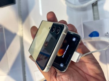 Köln, Almanya - 30 Eylül 2021: Bir Alman fotoğrafçı yeni Samsung Galaxy Z Flip 3 modelini Satürn 'ün elektronik pazarında izleyerek bir alışveriş malını ziyaret ediyor.