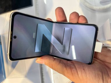 Köln, Almanya - 30 Eylül 2021: Bir Alman fotoğrafçı yeni Samsung Galaxy Z Flip 3 modelini Satürn 'ün elektronik pazarında izleyerek bir alışveriş malını ziyaret ediyor.