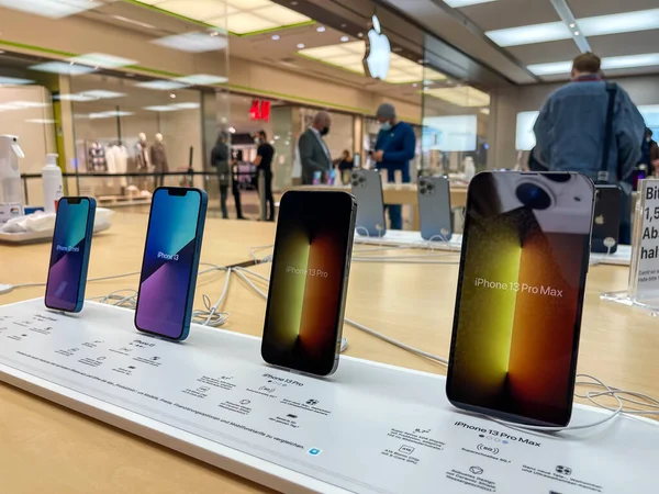 Köln, Almanya - 1 Ekim 2021: Yeni iPhone 13 'ün yanı sıra iPhone 13 Pro ve iPhone 13 Mini' yi Apple Store 'da karşılaştıran ve test eden bir Alman fotoğrafçı.