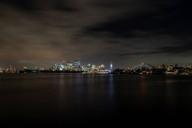 Sydney, Avustralya - 10 Şubat 2020: Avustralya 'da Sydney' i ziyaret eden bir Alman fotoğrafçı, yazın bulutlu ama sıcak bir günde Opera binasıyla ufuk çizgisinin fotoğraflarını çekiyor.