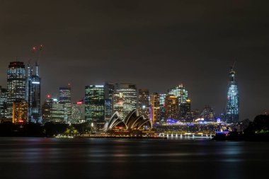 Sydney, Avustralya - 10 Şubat 2020: Avustralya 'da Sydney' i ziyaret eden bir Alman fotoğrafçı, yazın bulutlu ama sıcak bir günde Opera binasıyla ufuk çizgisinin fotoğraflarını çekiyor.