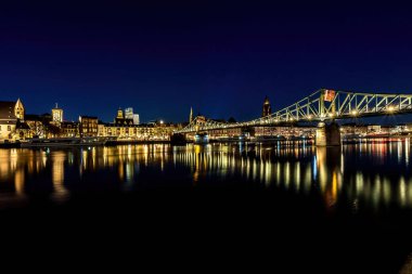 Frankfurt 'ta Eiserner Steg adında bir köprü, soğuk bir kış gününde geceleyin şehrin manzarası ile ana caddede..