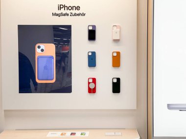 Köln, Almanya - 10 Kasım 2021: Bir Alman fotoğrafçı aksesuarları yeni iPhone 13 'ün yanı sıra bir Apple Store' daki iPhone 13 Pro 'nun telefon kılıfı olarak karşılaştırıyor.