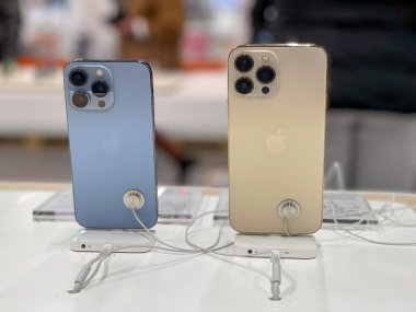 Köln, Almanya - 1 Ekim 2021: Yeni iPhone 13 'ün yanı sıra iPhone 13 Pro ve iPhone 13 Mini' yi Apple Store 'da karşılaştıran ve test eden bir Alman fotoğrafçı.