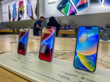 New York, ABD - 16 Eylül 2022: Bir Alman fotoğrafçı yeni iPhone 14 'ün yanı sıra bir Apple Store' da iPhone 14 Pro modellerini karşılaştırıp test ediyor.
