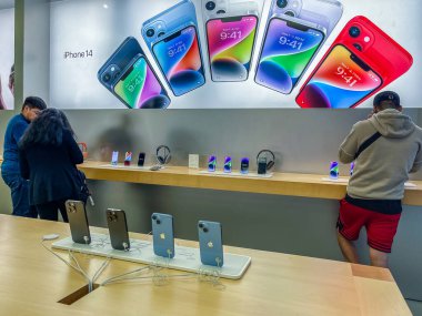 New York, ABD - 16 Eylül 2022: Bir Alman fotoğrafçı yeni iPhone 14 'ün yanı sıra bir Apple Store' da iPhone 14 Pro modellerini karşılaştırıp test ediyor.