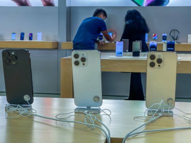 New York, ABD - 16 Eylül 2022: Bir Alman fotoğrafçı yeni iPhone 14 'ün yanı sıra bir Apple Store' da iPhone 14 Pro modellerini karşılaştırıp test ediyor.