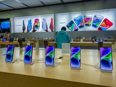 New York, ABD - 16 Eylül 2022: Bir Alman fotoğrafçı yeni iPhone 14 'ün yanı sıra bir Apple Store' da iPhone 14 Pro modellerini karşılaştırıp test ediyor.