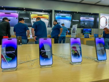 New York, ABD - 16 Eylül 2022: Bir Alman fotoğrafçı yeni iPhone 14 'ün yanı sıra bir Apple Store' da iPhone 14 Pro modellerini karşılaştırıp test ediyor.