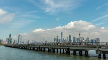 New Jersey 'deki Liberty State Park' ta güneşli bir sonbaharda ön planda yürüyüş yolu bulunan Manhattan 'ın 4k' lik zaman çizelgesi..