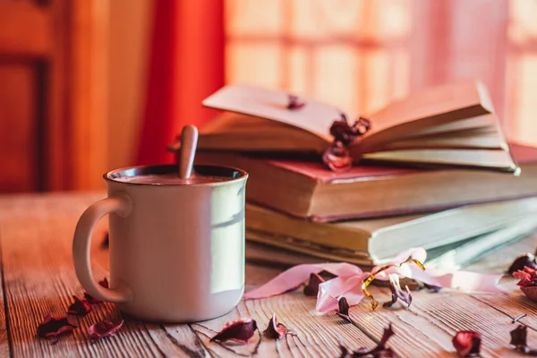 Kahveli bir kupa mı yoksa ahşap bir masanın üzerinde eski bir kitap yığını olan sıcak çikolata mı?