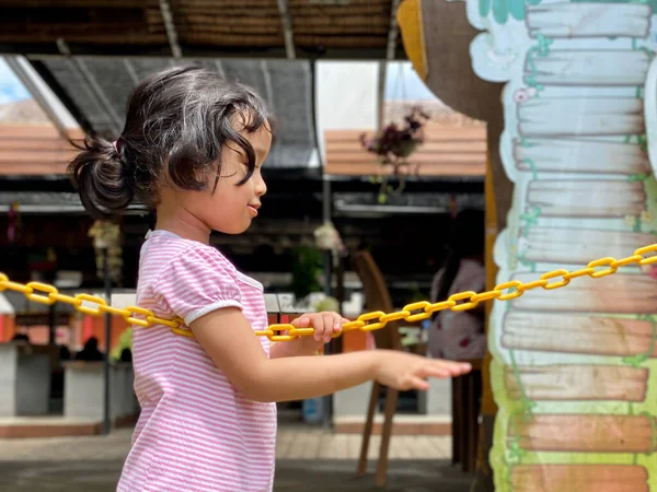 little girl playing with chain at the playground