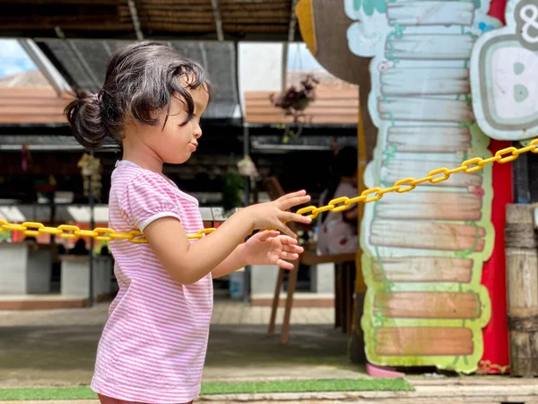 little girl playing with chain at the playground