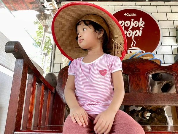 little girl and traditional woven bamboo hat