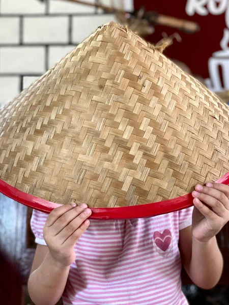 little girl and traditional woven bamboo hat