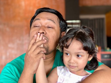 Father and daughter playing together at restaurant, enjoying togetherness