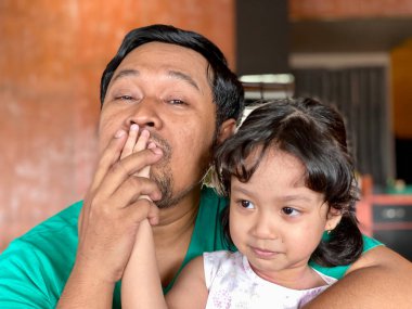 Father and daughter playing together at restaurant, enjoying togetherness
