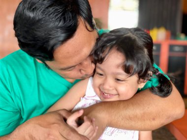Father and daughter playing together at restaurant, enjoying togetherness
