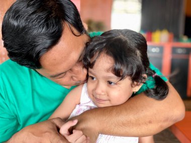 Father and daughter playing together at restaurant, enjoying togetherness