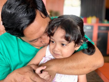 Father and daughter playing together at restaurant, enjoying togetherness