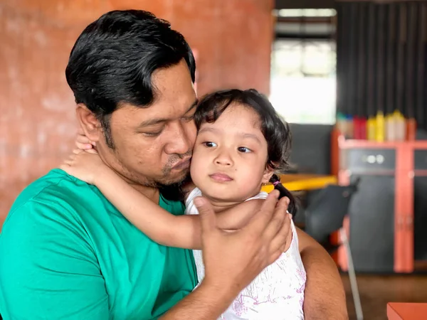 Father and daughter playing together at restaurant, enjoying togetherness